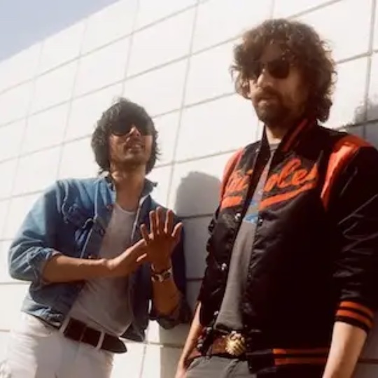 Two musicians by a wall